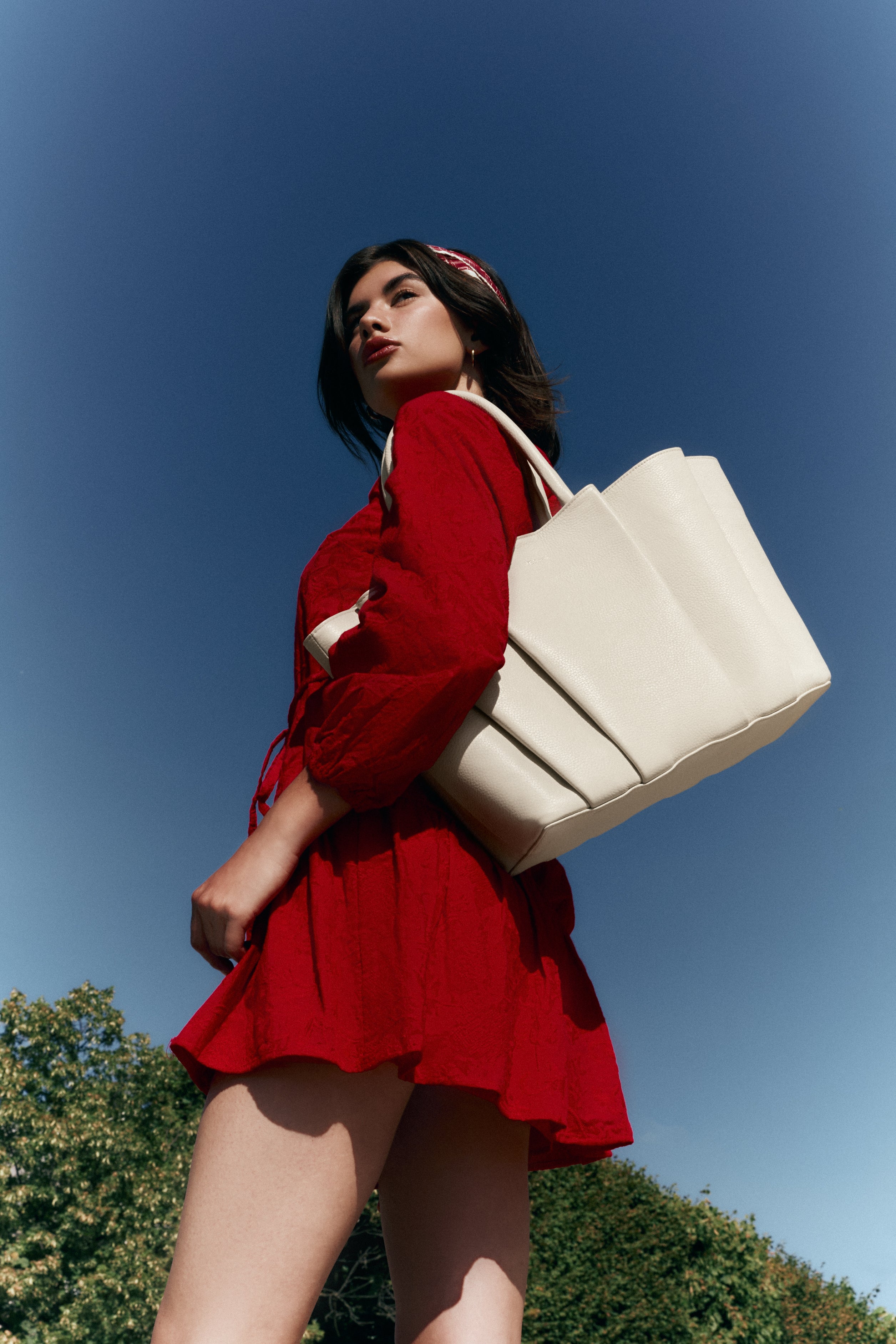 Sac cabas OZI Crème en cuir grainé, porté par une femme.